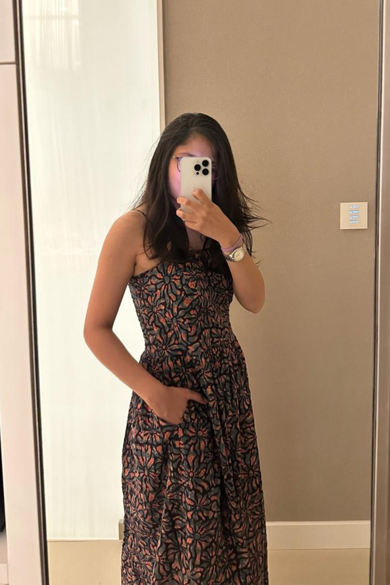 Person wearing a patterned dress taking a mirror selfie.